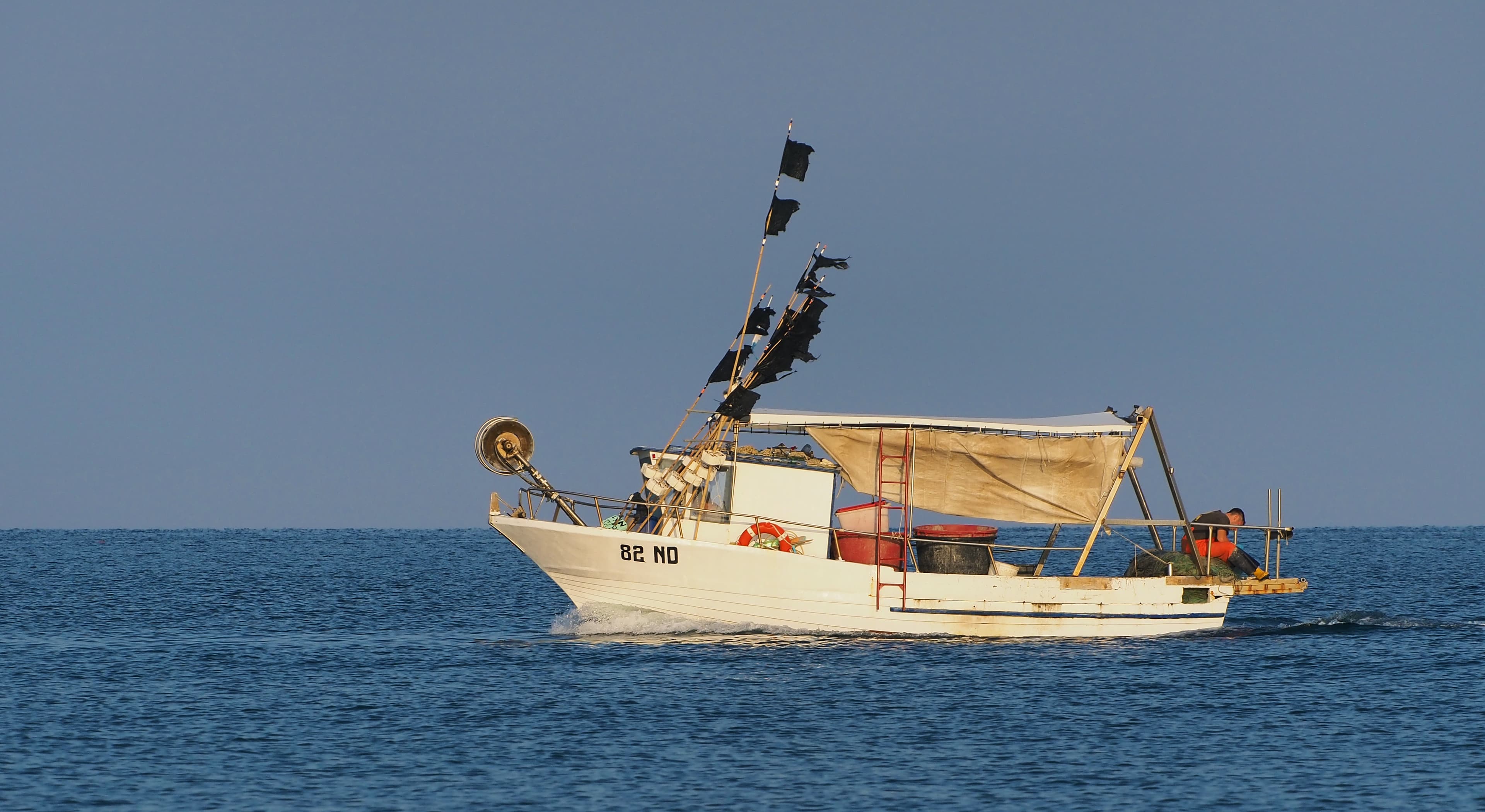 Un piccolo peschereccio bianco naviga sul mare Adriatico