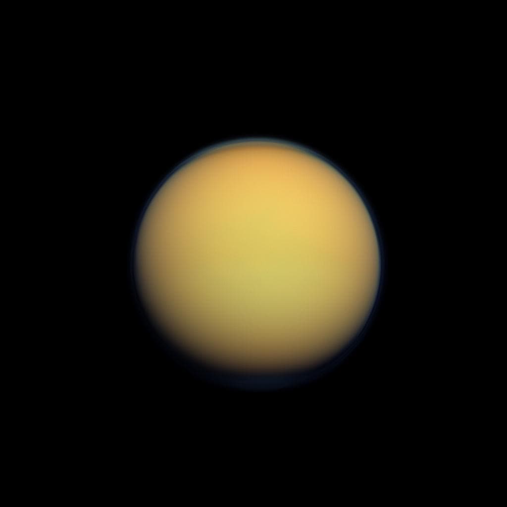 Il globo arancione di Titano, circondato da una tenue foschia blu.
