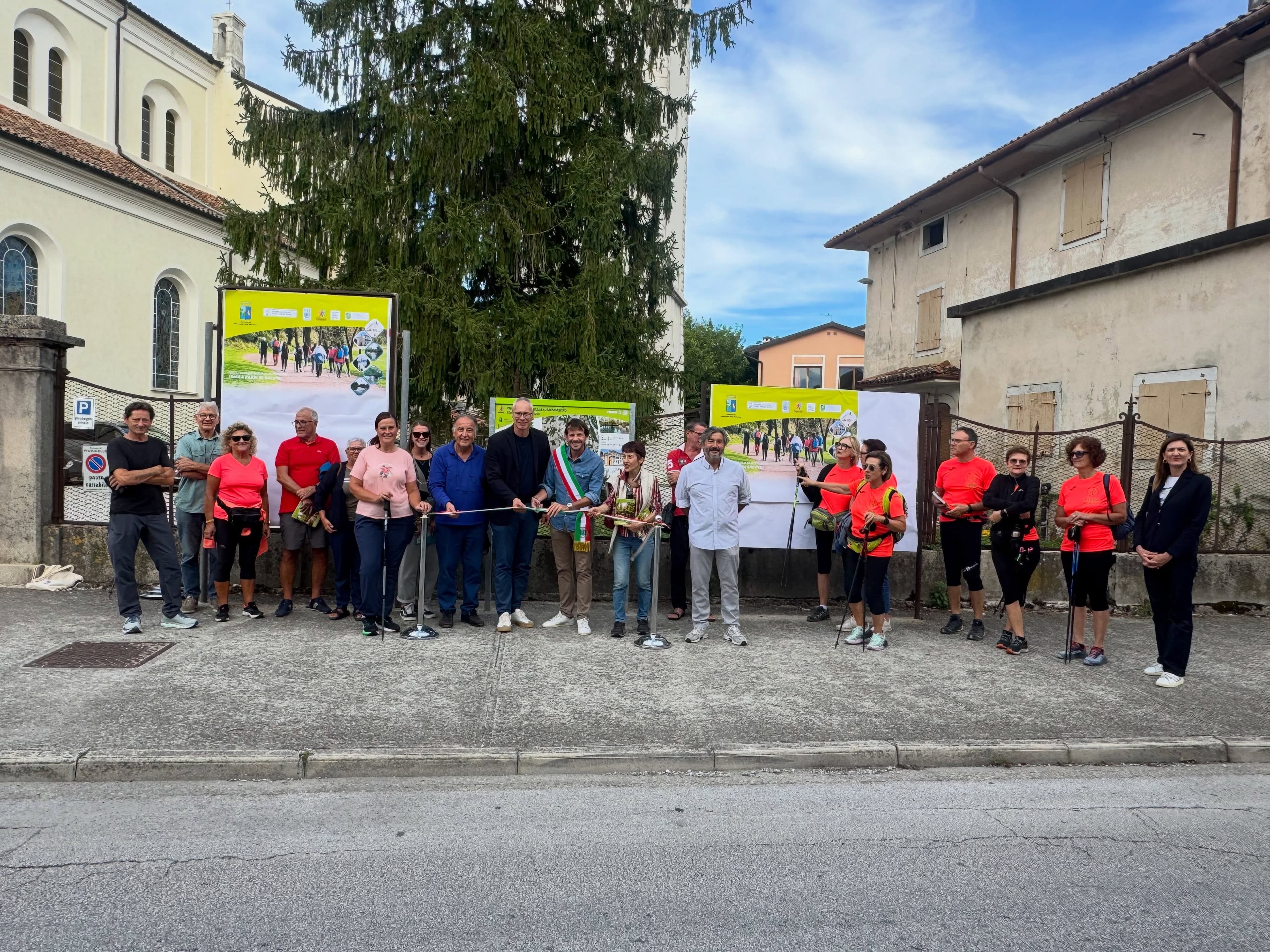 Partecipanti al taglio del nastro davanti ai pannelli del percorso.