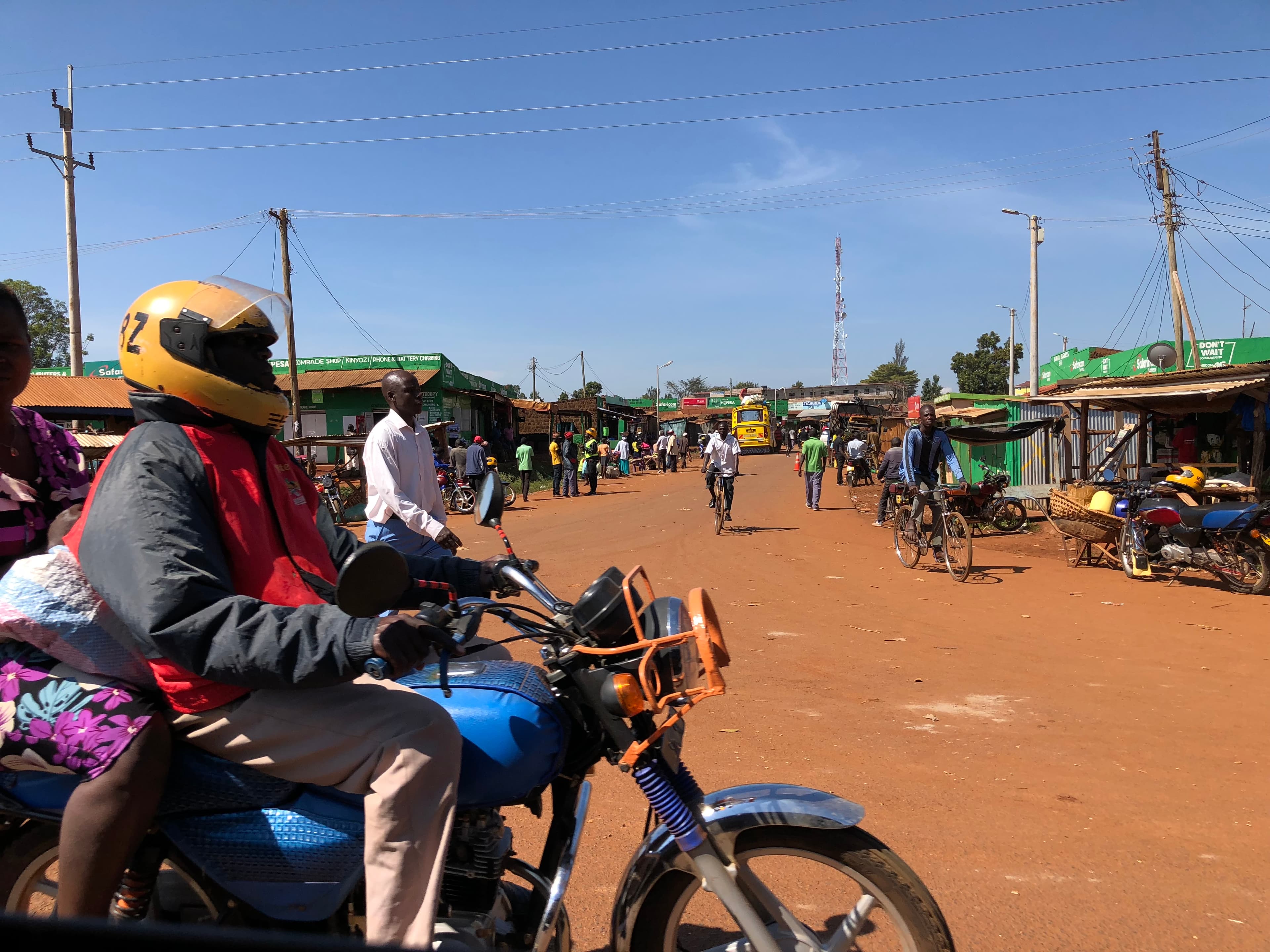 Strada di Busia con motociclette, pedoni e attività commerciali.