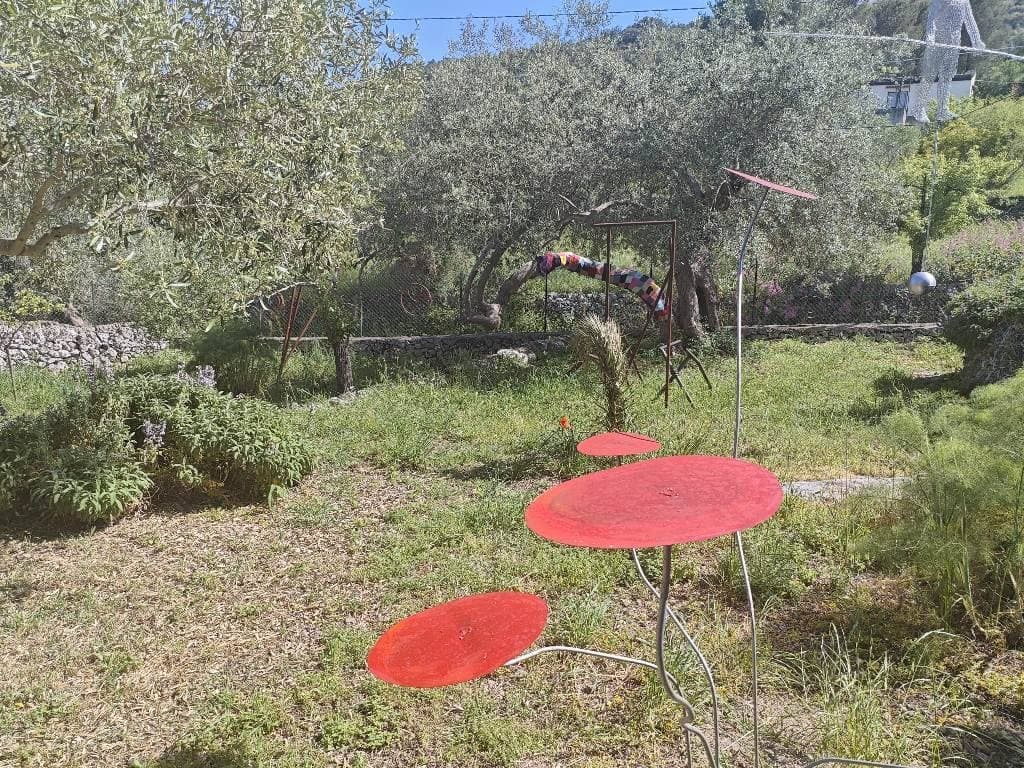 Sculture con dischi rossi e altre forme metalliche tra gli ulivi del Parco Giardino Bianco