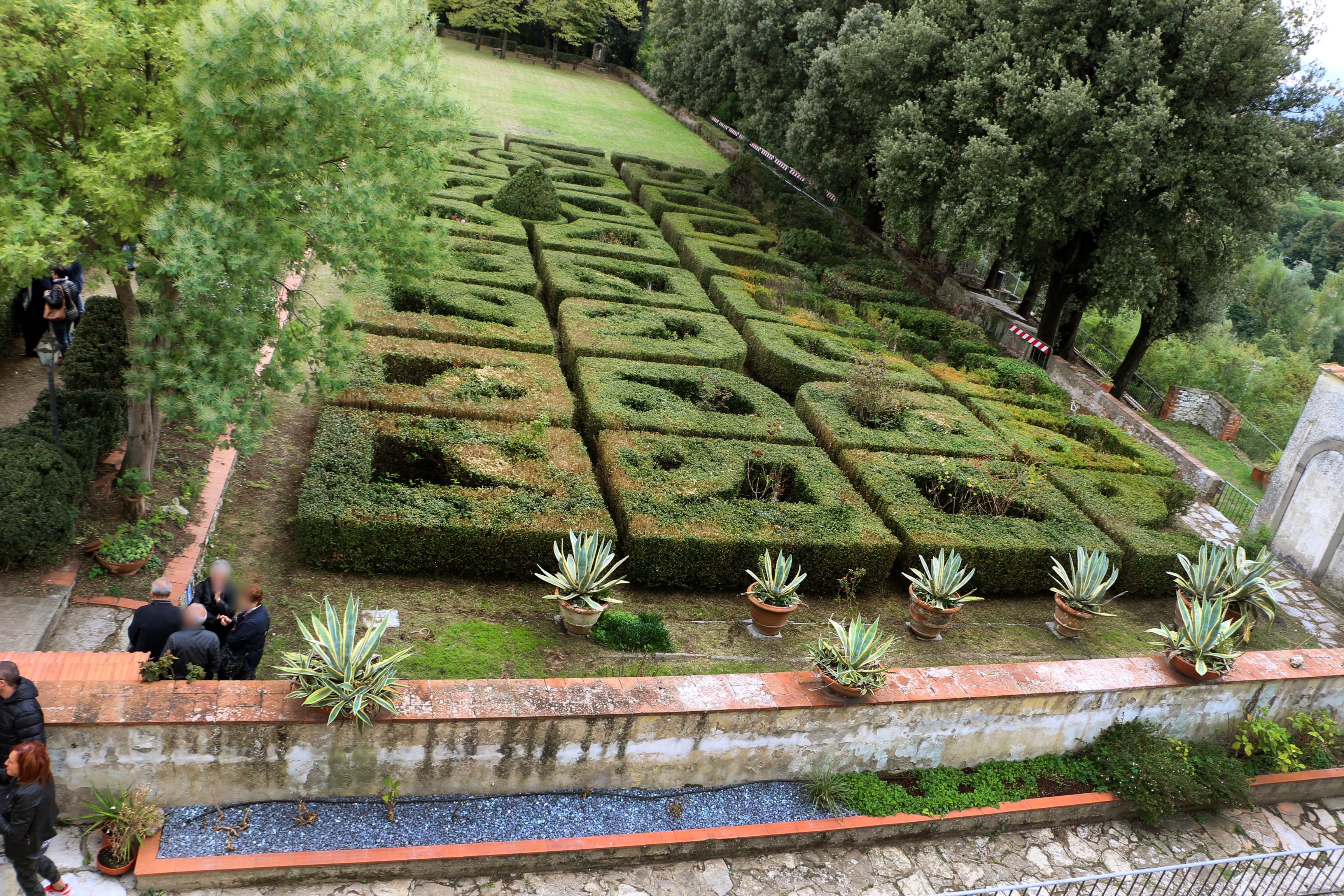 Il giardino all’italiana di Villa del Palco, con siepi geometriche, alberi e vasi lungo la terrazza