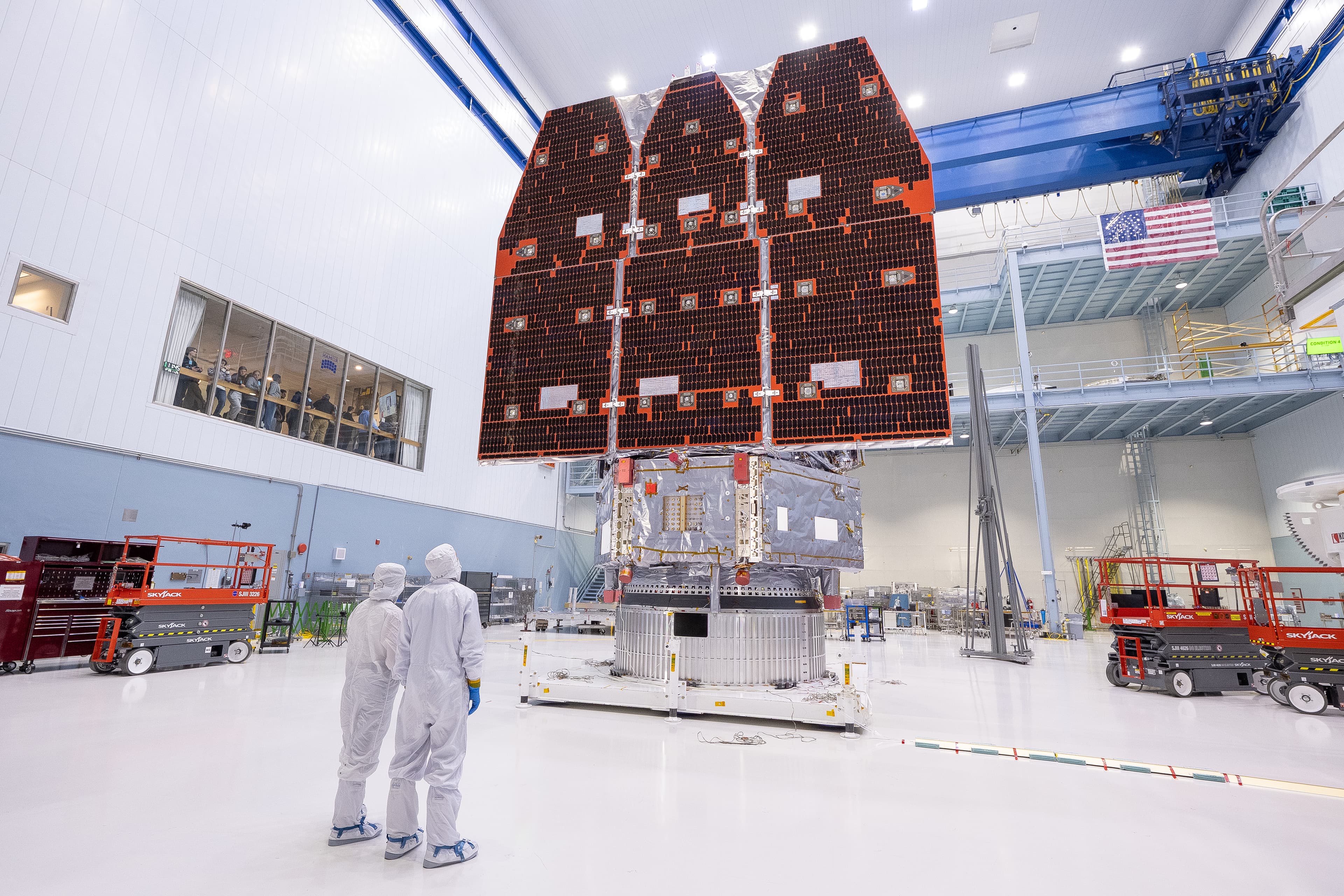 Il telescopio spaziale Roman assemblato nella camera bianca, con due tecnici in tuta protettiva