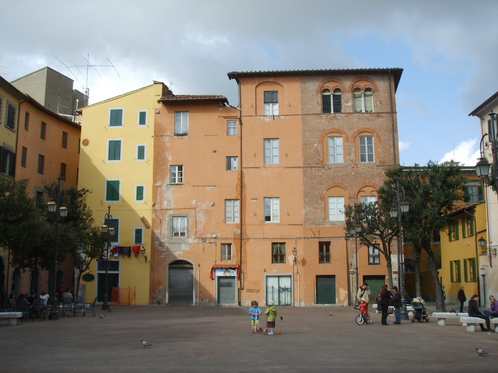 Piazza Chiara Gambacorti a Pisa, con facciate color ocra e persone nello spazio pedonale; immagine di repertorio.