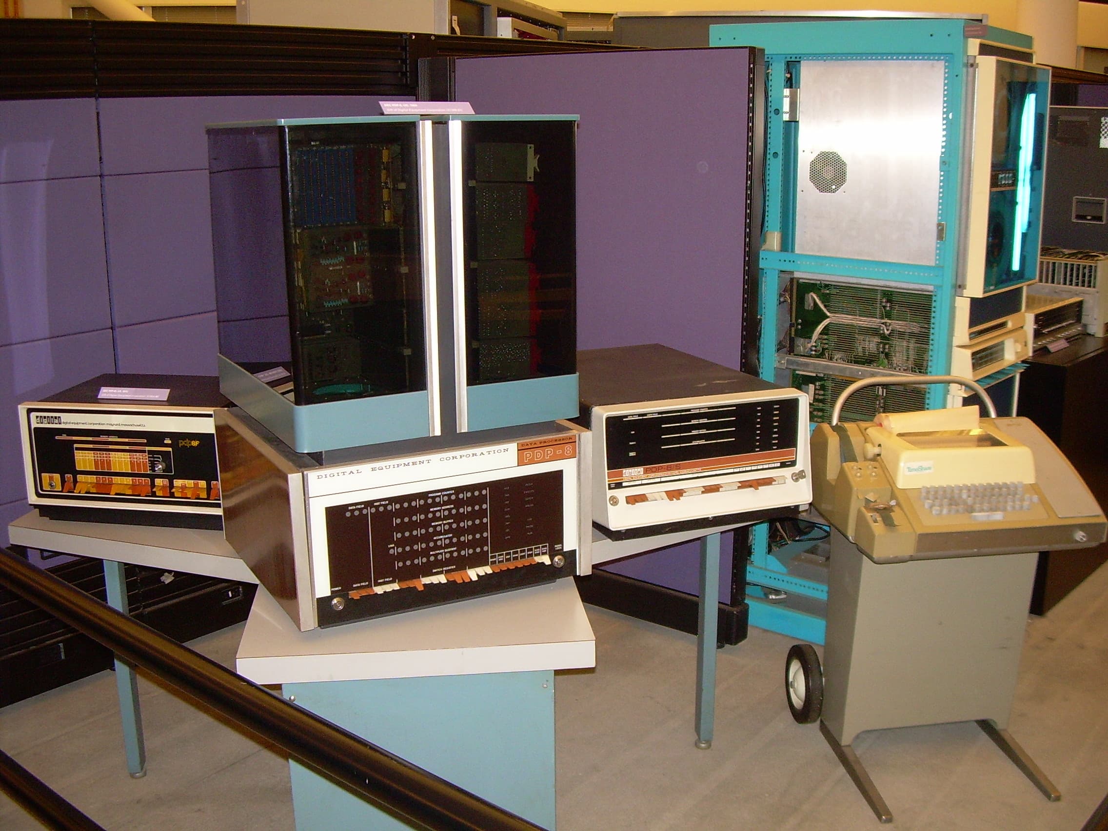 Computer della famiglia PDP-8 esposti in un museo, con pannelli di interruttori e una telescrivente