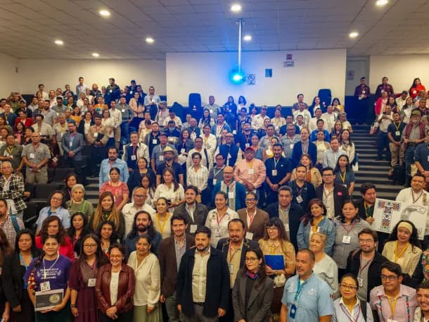 I partecipanti al forum sul turismo comunitario posano insieme in un’aula universitaria.