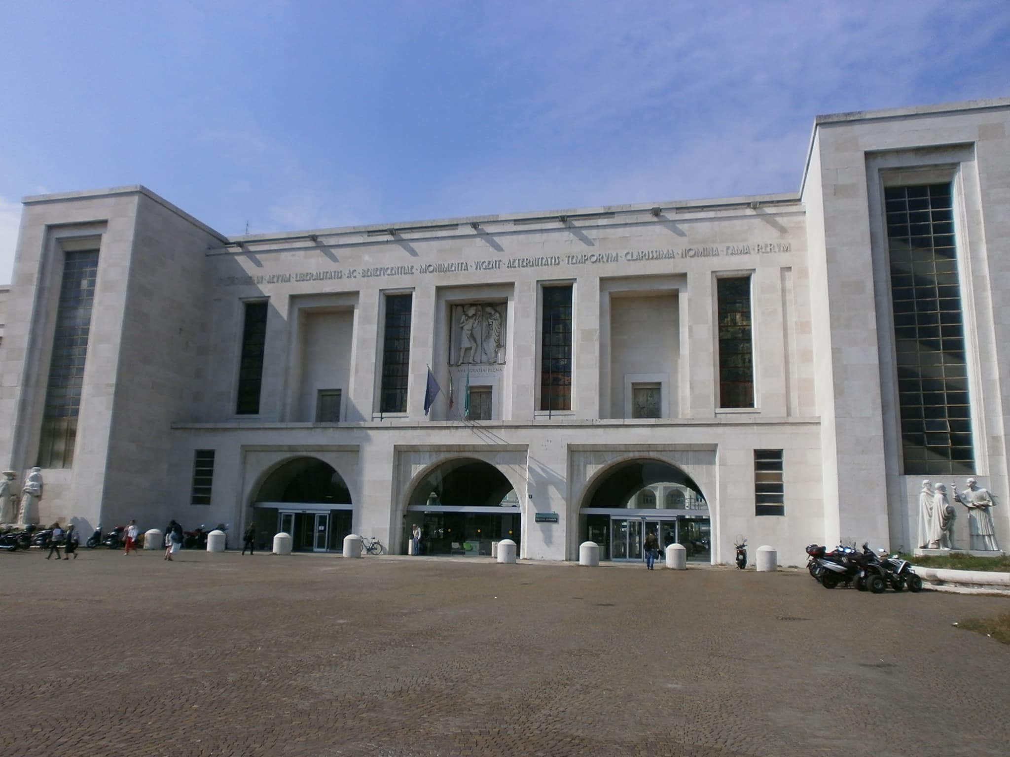 La facciata chiara dell’ospedale Niguarda, con tre ingressi ad arco e alte finestre.