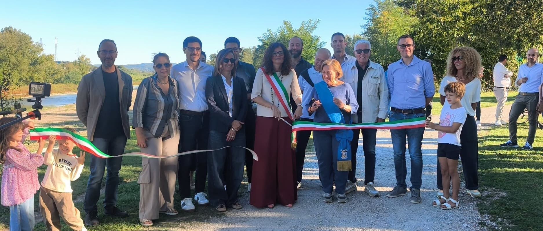 Un gruppo di persone accanto al nastro tricolore durante la presentazione dei lavori sulle sponde dell’Arno.