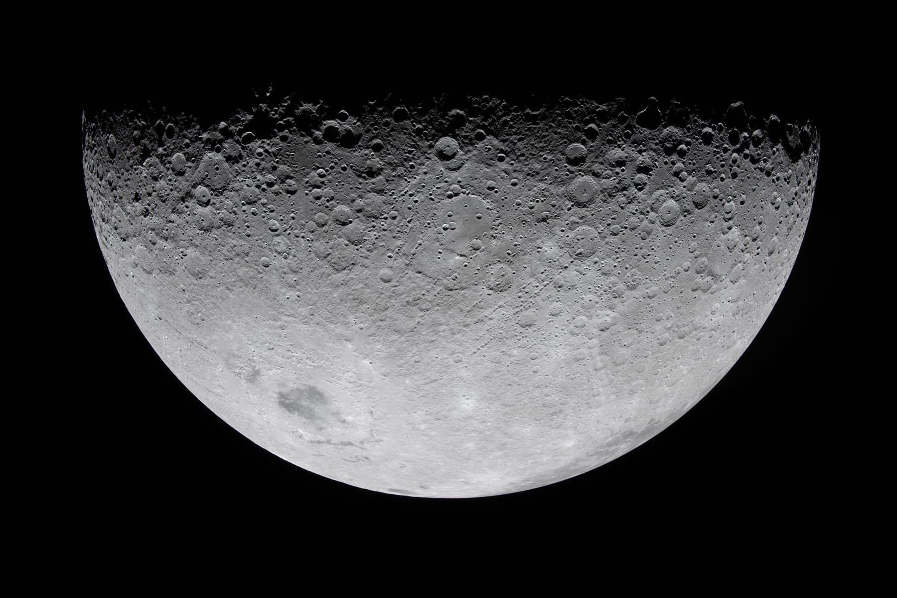 Illuminated lunar surface and craters along the boundary with shadow