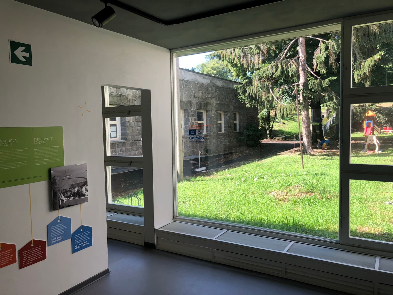 Una vetrata del Nido Olivetti di Ivrea affacciata sul giardino e sulle pareti in pietra