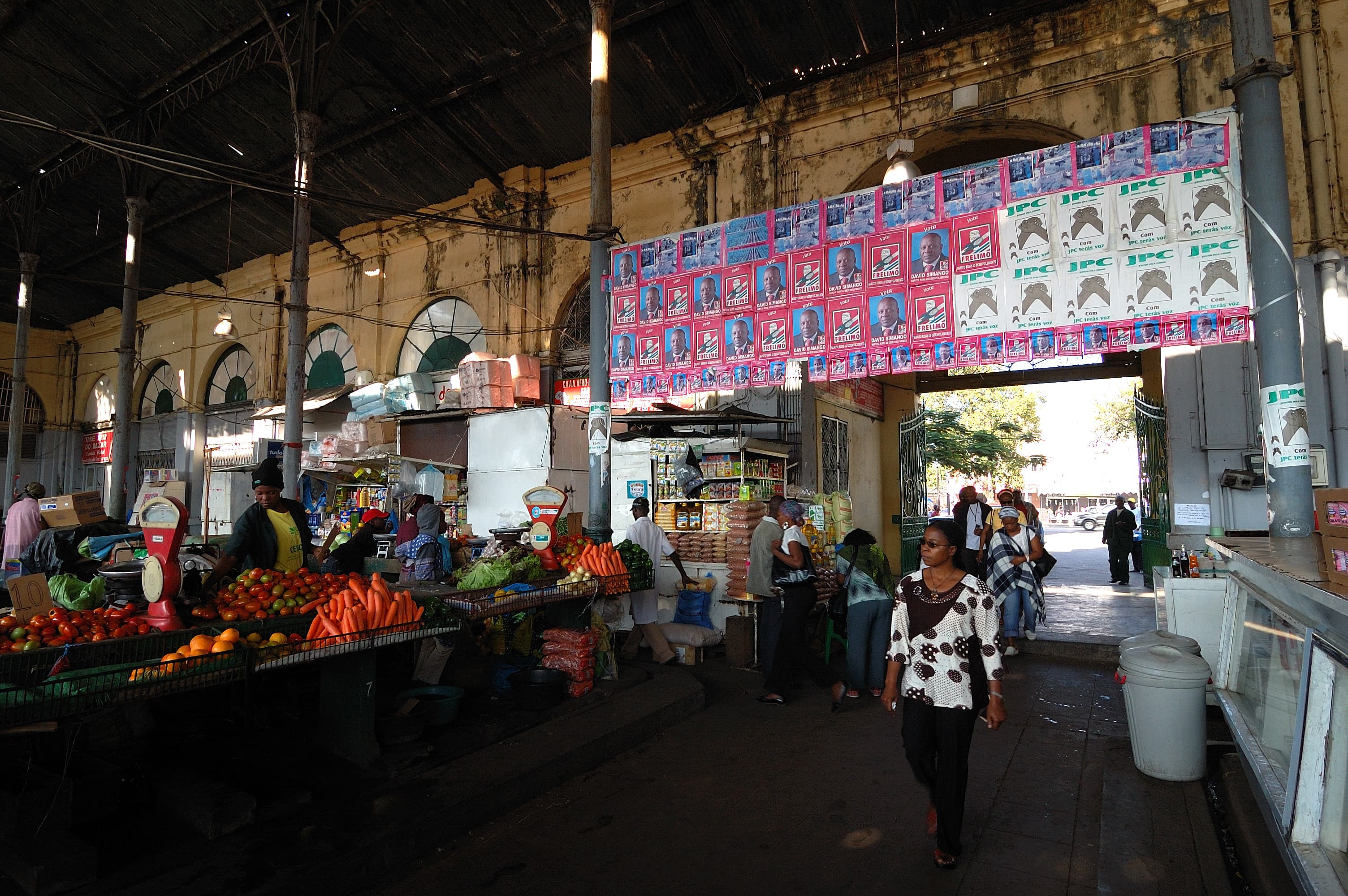 Banchi di frutta e verdura, venditori e clienti dentro il mercato municipale di Maputo